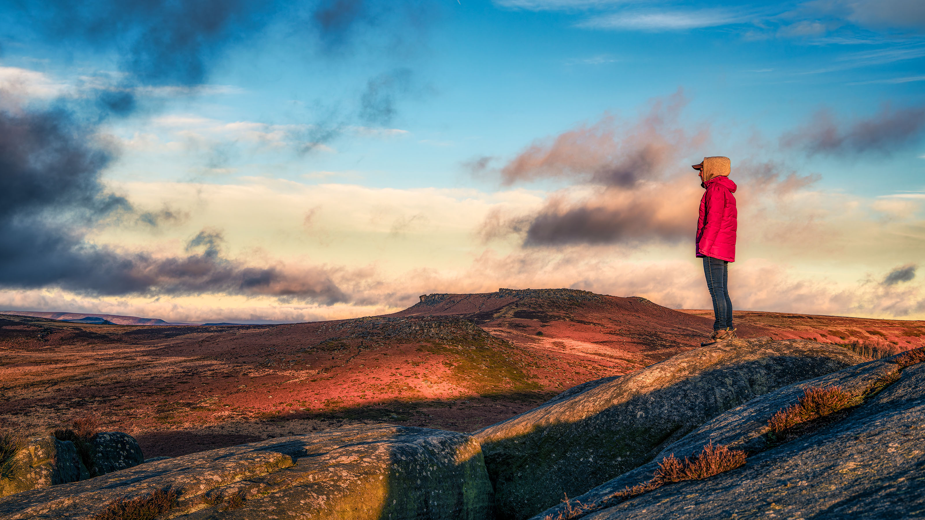 A solitary figure in a red coat looking across Hope Valley